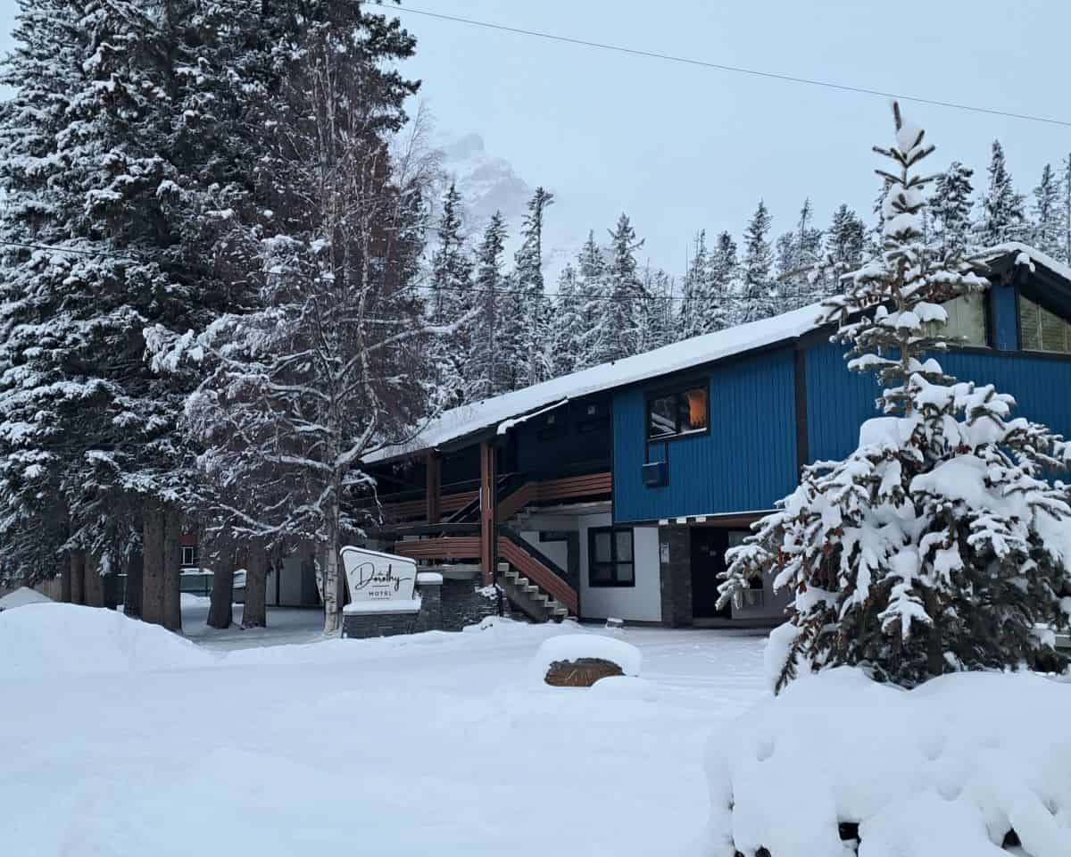 The blue of the Dorothy Motel in Banff contrasts against a snowy winter scene.