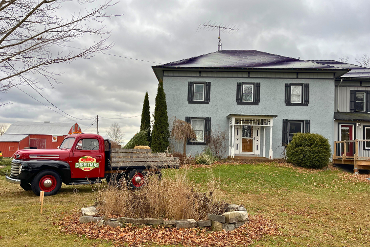 Two-story grey farmhouse at The Christmas Farm is a magical winter adventure in Harrowsmith, Ontario.