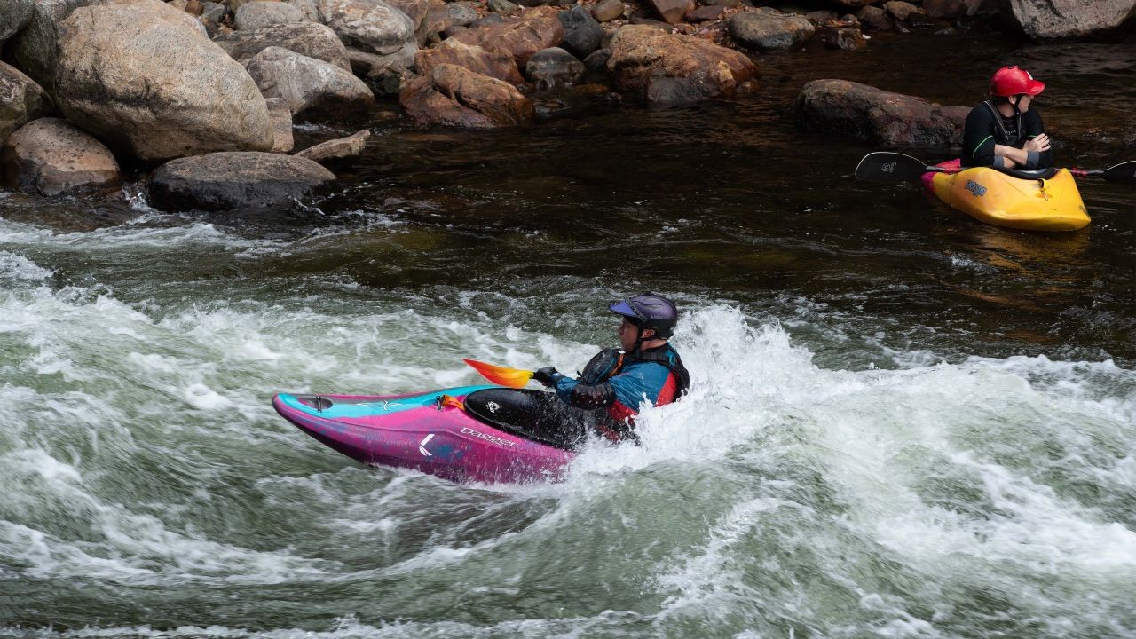 Kayakers play in white water at the Minden whitewater preserve in Ontario Canada.