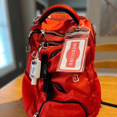 Bright red backpack with a label that says, 