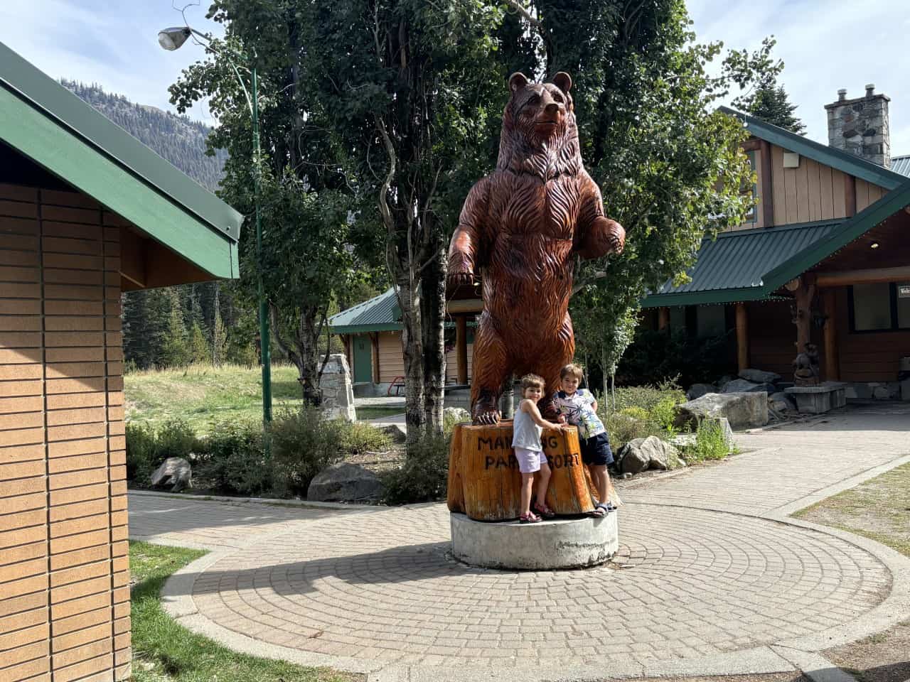 Bear carving at Manning Park Resort 2024-09-29 - This is one of the largest carvings at Manning Park Resort. Here are some children posing with the bear.